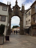 Arco da Porta Nova, where a sinister figure follows Maria and Paulo without their immediate knowledge.